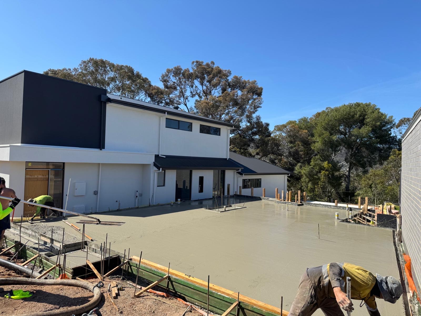 Completed residential concrete slab beside a modern home